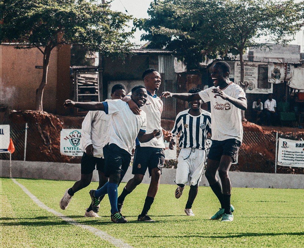 A group of young footballers celebrating together on a pitch