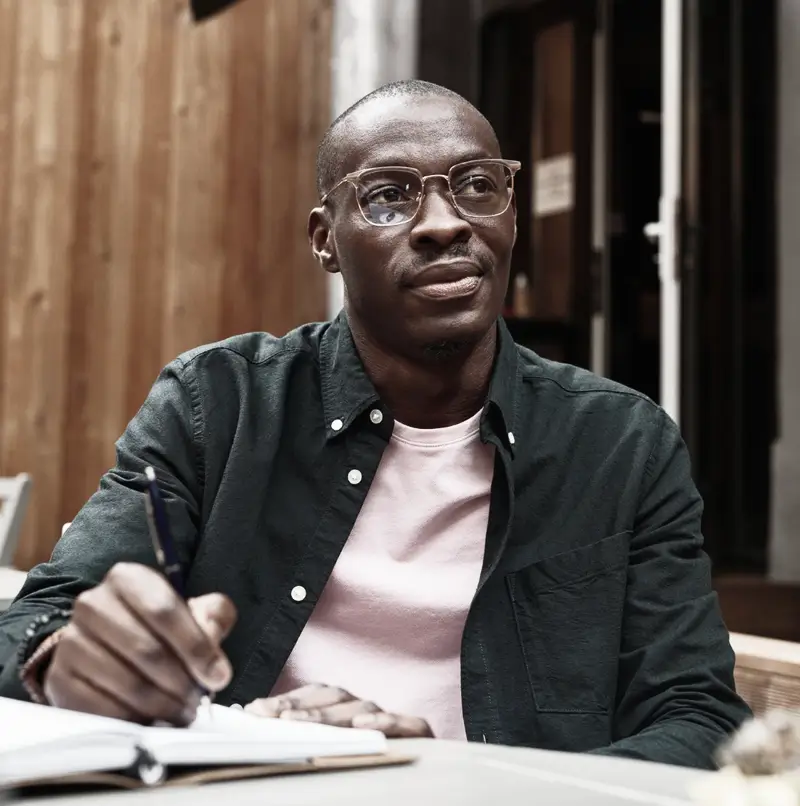 A contributor writing in a notebook